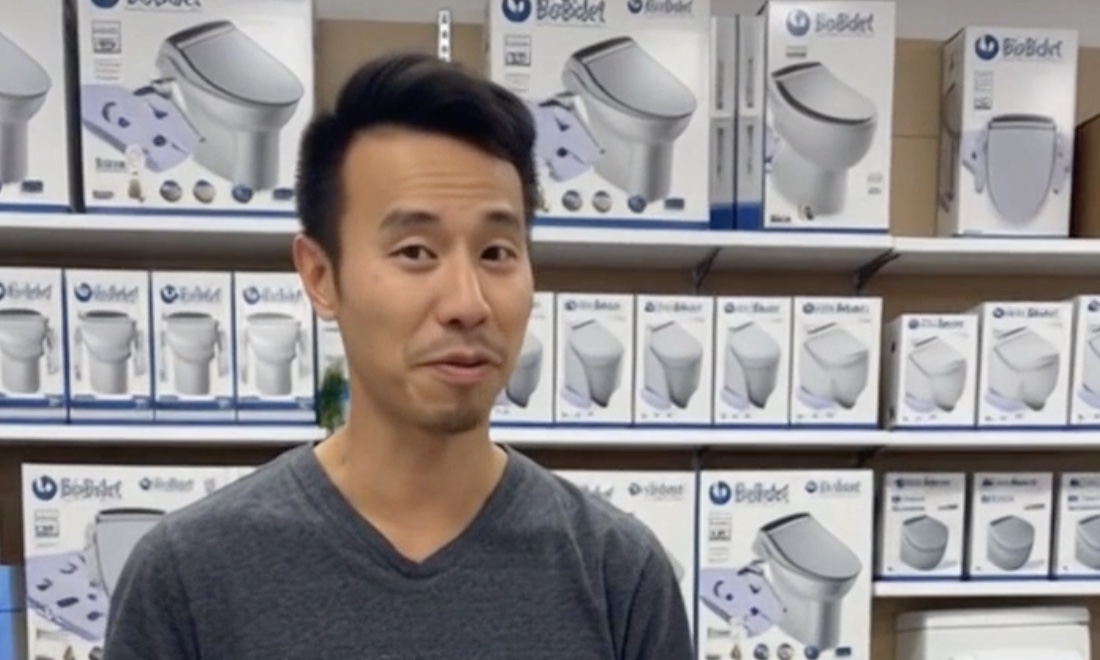 Phil standing in front of a wall of bioBidet bidet seat boxes