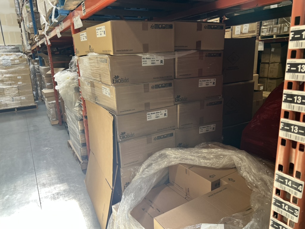 Pallets of bioBidet Slim 3 boxes on warehouse shelving, ready to ship