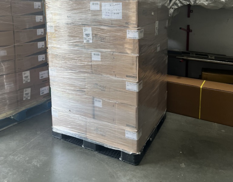 Shrink-wrapped pallet of boxed orders in the Toiletland warehouse, ready to ship