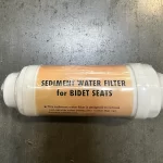 Sediment water filter for bidet seats with an orange label, inline filter with white end fittings